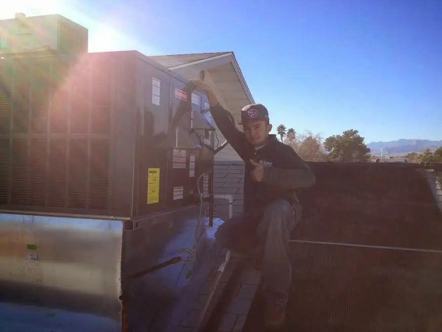 HVAC technician performing Air Duct Cleaning on a rooftop unit in Great Neck